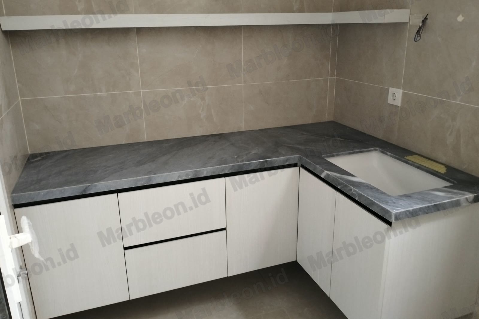 Top dapur marmer abu-abu bentuk L di atas kabinet putih