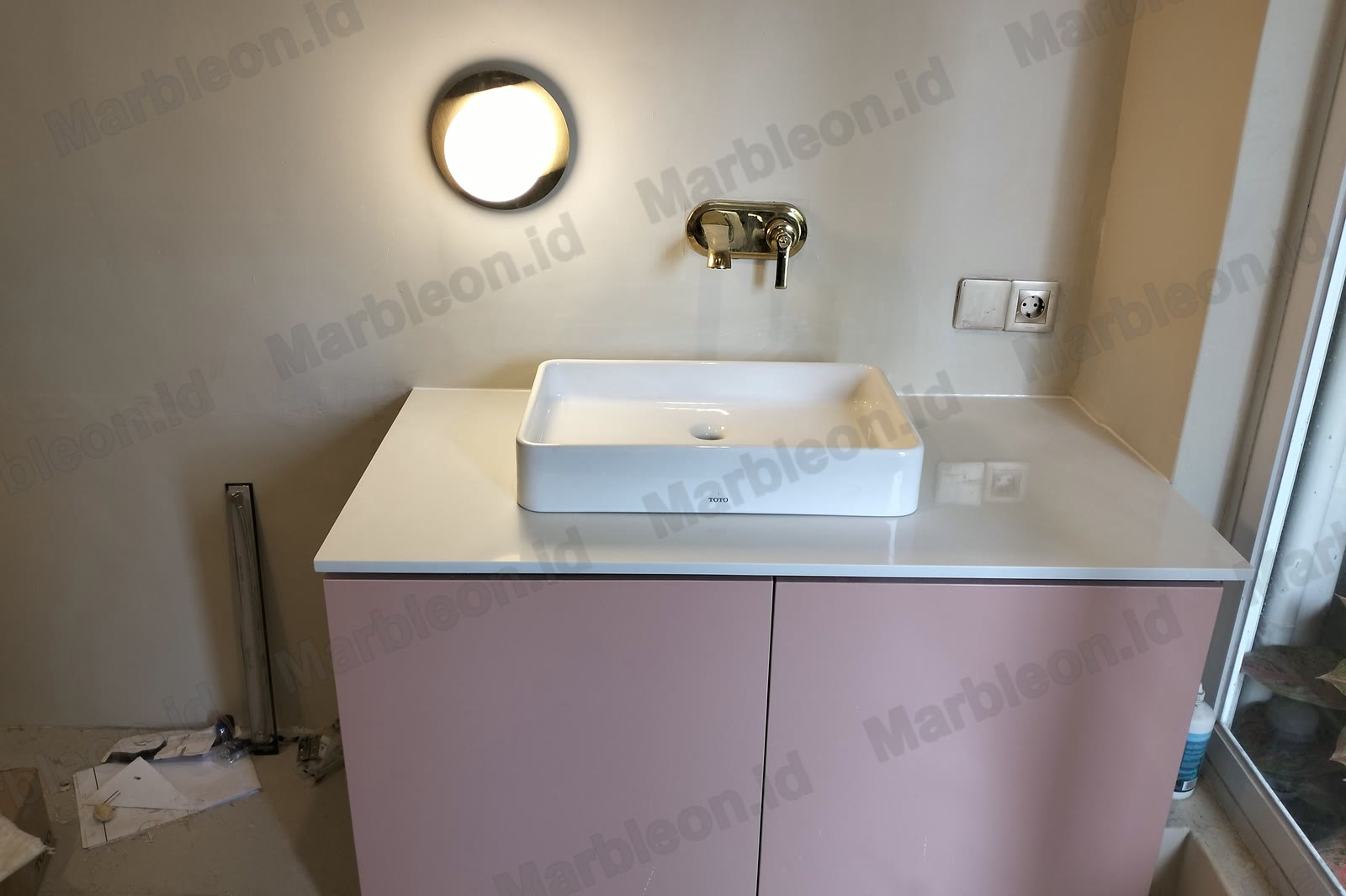 Top wastafel putih di atas kabinet merah muda